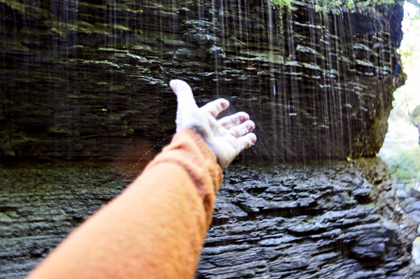 Karen feels the coolness of the water at Rainbow Falls